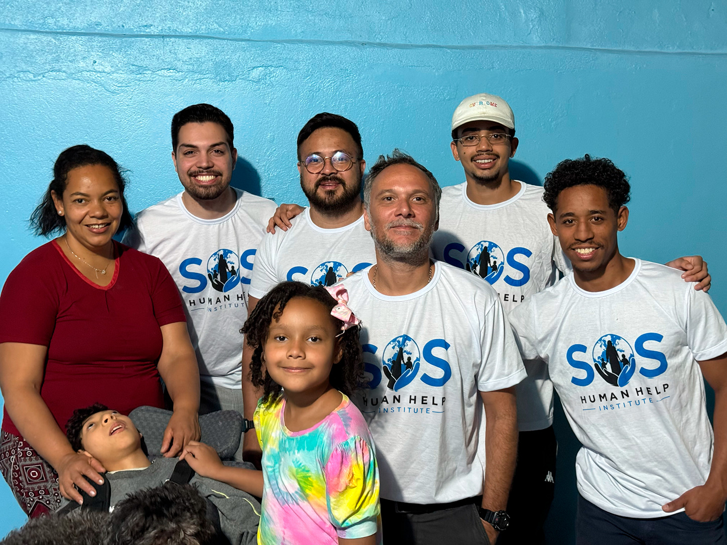 Equipe do SOS Human Help com a m&atilde;e e os dois filhos atendidos pela ONG